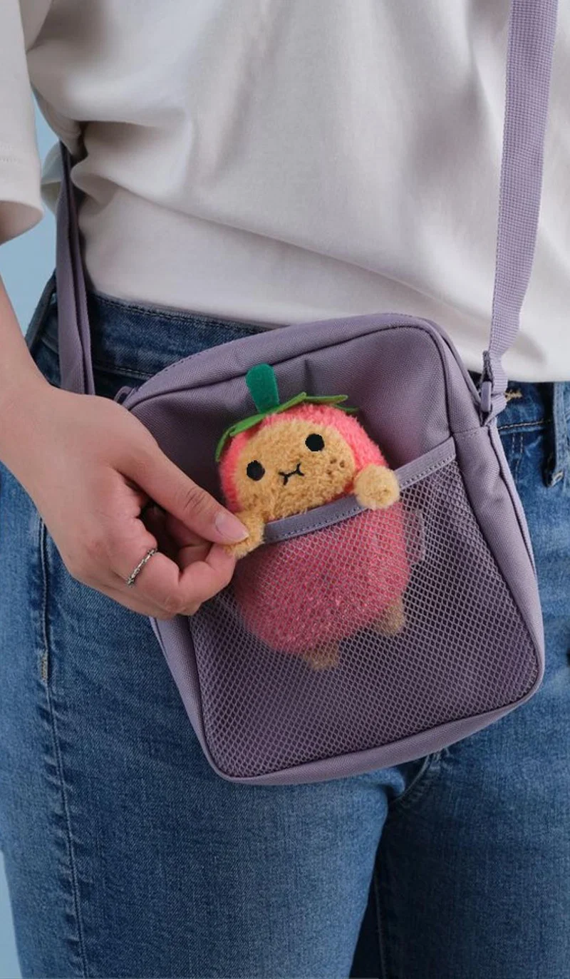 Small fruit plush toy in a shoulder bag