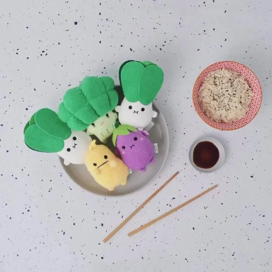 Hands arranging a playful green caterpillar snack